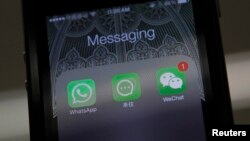 Whatsapp、阿里巴巴的来往和微信的图标并列在北京拍摄的一只手机上。（2014年2月24日）