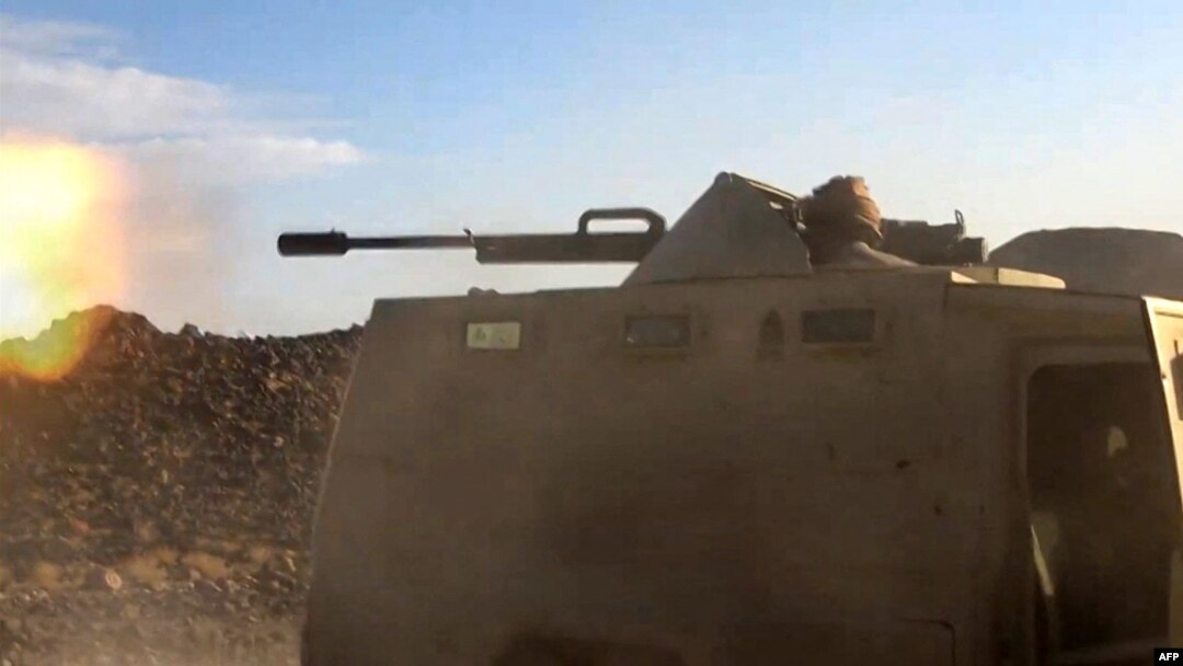 Seorang pejuang yang setia kepada pemerintah Yaman yang didukung Saudi, menembakkan senjata dari kendaraan lapis baja dalam bentrokan melawan pasukan pemberontak Houthi di dekat Marib, 25 April 2021. (AFPTV / AFP)