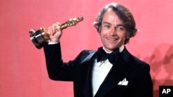 FILE - John C. Avildsen shows off the Oscar he won for best director for "Rocky," at the Academy Awards in Los Angeles, March 28, 1977. Avildsen has died at age 81. 