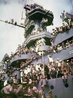 FILE - Servicemen, reporters, and photographers perch on the USS Missouri on Sept. 2, 1945, for the onboard ceremony in which Japan surrendered in Tokyo Bay, ending World War II.