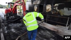 A worker of French construction group Vinci cleans near a damaged payment booth a day after the highway toll was set on fire on Dec. 18, 2018 in Bandol, near Marseille, southern France, following Yellow vests protests.