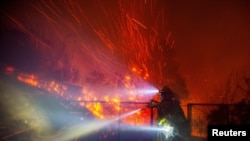 El viento levanta las brasas de los árboles mientras un bombero trabaja en el incendio Franklin en Malibú, California, EEUU, el 10 de diciembre de 2024.