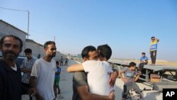 FILE —Palestinian day laborers in Israel arrive in the Gaza Strip at the Kerem Shalom crossing brought by the Israeli authorities November 3, 2023.