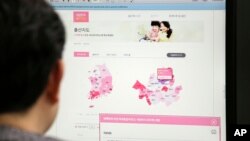 A journalist watches a screen showing a press release from the South Korean Ministry of the Interior about the birth map showing the number of women in childbearing age in Seoul, South Korea, Dec. 30, 2016.