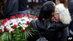 Mourners hug each other during a state funeral for some of the victims of last Wednesday's earthquake, in Amatrice, central Italy, Aug. 30, 2016. 