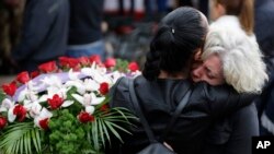 2016年8月30日意大利地震受害者集体葬礼上送葬者互相拥抱。