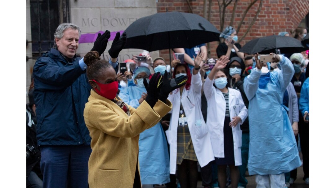 Mayor Bill de Blasio and his wife Chirlane McCray applaud healthcare workers at Brooklyn's Kings County Hospital Center during a 7 o'clock ceremony, April 24, 2020, in New York.