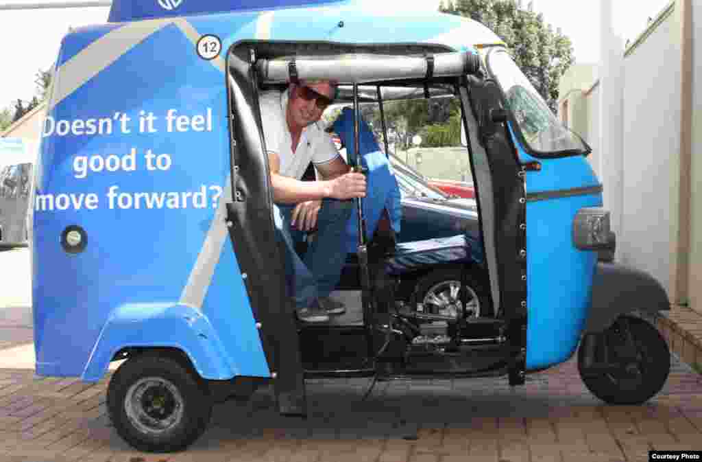 Bruce Cowie, Shesha Tuks managing director, demonstrates passenger seating. He hires experienced drivers from countries such as Malawi and Congo where tuk tuks have a long history. (Photo by Darren Taylor)