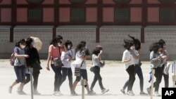 Siswa-siswa SMP Korea Selatan mengenakan masker guna menghindari kemungkinan terjangkit virus MERS saat kunjungan ke istana Gyeongbok di Seoul (3/6). 