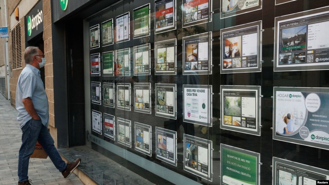 A man wearing a face mask looks at the window of Don Piso real estate agency office during the coronavirus disease (COVID-19) outbreak in El Masnou, north to Barcelona, Spain, May 19, 2020.