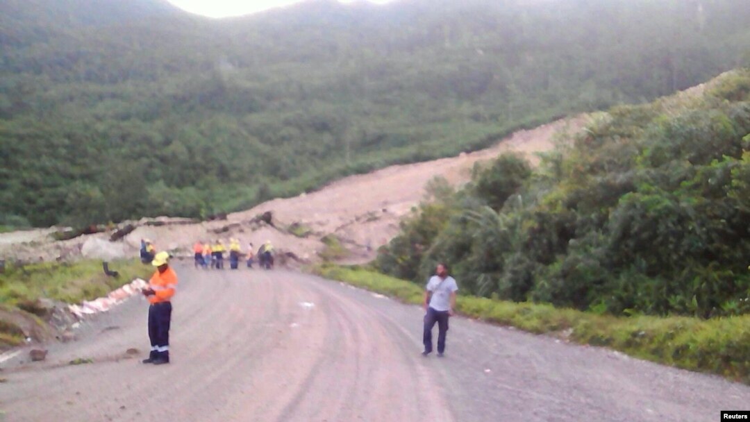 Gambar warga setempat sedang memeriksa lokasi longsor dan kerusakan di sebuah jalan dekat Kota Tabubil setelah gempa di Dataran Tinggi Selatan di Papua Nugini, 26 Februari 2018. (Jerome Kay/Handout via Reuters)