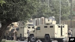 Private security personnel stand guard at the site of a bomb attack in Baghdad June 6, 2011