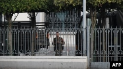 A soldier looks out from the City Hall compound in Yangon on Feb. 1, 2021, as Myanmar's military detained the country's de facto leader Aung San Suu Kyi and the country's president in a coup. 