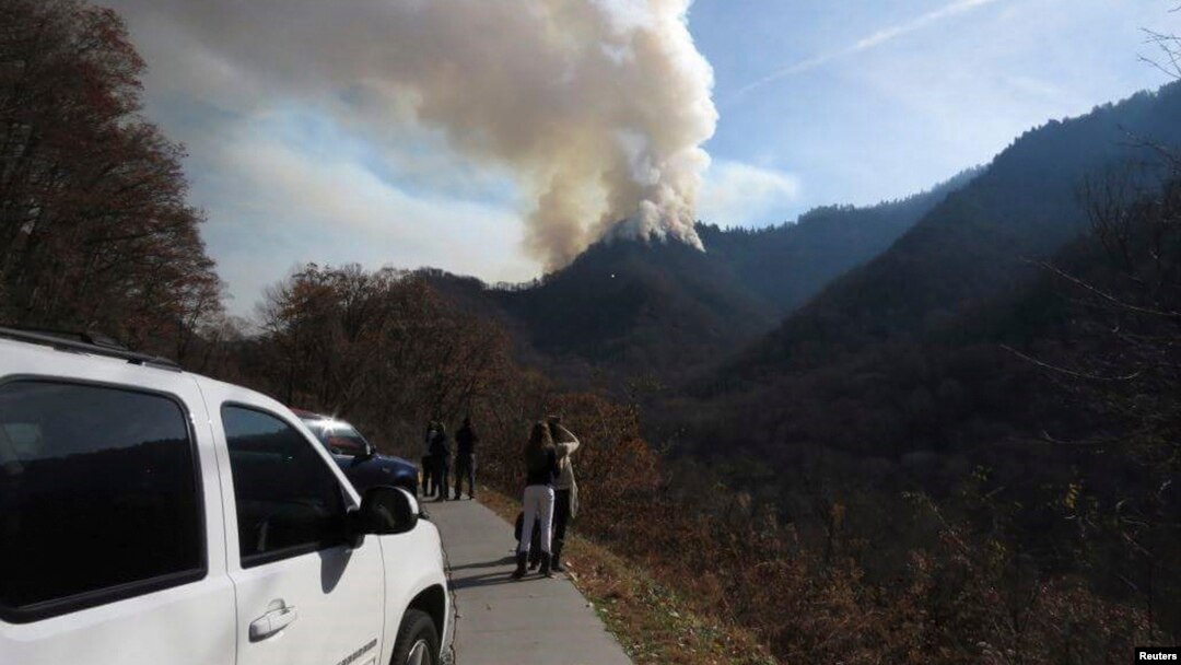 Para pengendara berhenti di pinggir jalan untuk melihat kebakaran hutan di Great Smokey Mountains dekat Gatlinburg, Tennessee, AS (28/11). 