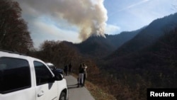 Para pengendara berhenti di pinggir jalan untuk melihat kebakaran hutan di Great Smokey Mountains dekat Gatlinburg, Tennessee, AS (28/11). 