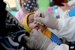 Seorang bayi menerima vaksinasi polio di sebuah puskesmas di Tangerang, 12 Mei 2020. (AP/Tatan Syuflana)