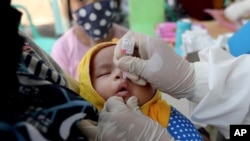 Seorang bayi menerima vaksinasi polio di Puskesmas Tangerang, Selasa, 12 Mei 2020. (Foto: AP/Tatan Syuflana)