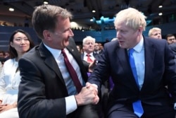 Jeremy Hunt, left, congratulates Boris Johnson after the announcement of the result in the ballot for the new Conservative party leader, in London, July 23, 2019.