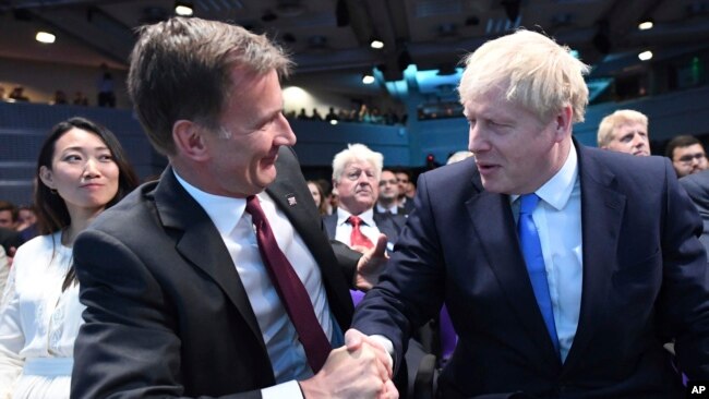 英国外相亨特祝贺约翰逊（右）当选英国首相。