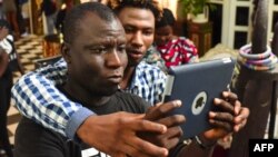 Deux participants à un atelier film avec leur smartphone le 30 mars 2019 lors de la 2ème édition du Bushman Film Festival, premier festival du film francophone d'Afrique de l'Ouest dédié au tournage sur smartphone, à Abidjan.