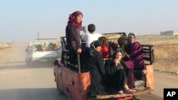 FILE - This photo provided by the Syria Press Center, an anti-government media group, shows civilians leaving the town of Suran, in Hama province, Sept. 1, 2016. 