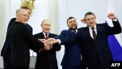 FILE - The Moscow-appointed heads of four Russian-occupied regions in Ukraine celebrate with Russian President Vladimir Putin after signing treaties annexing the regions, in Moscow, Sept. 30, 2022. Russia plans to hold presidential elections in the occupied areas in March 2024.