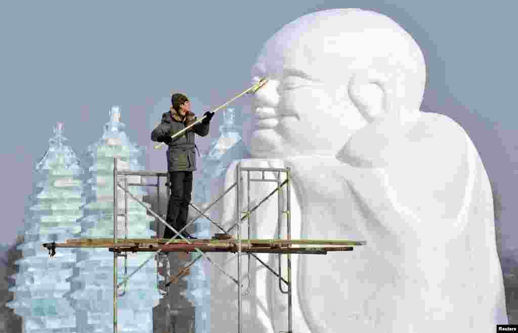 A man polishes a snow sculpture in preparation for Shenyang International Ice and Snow Festival, Liaoning province, China. The festival kicks off on January 10, 2013.