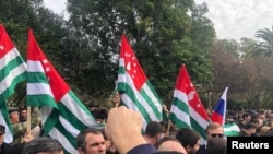 Sejumlah demonstran menggelar aksi unjuk rasa di luar gedung parlemen di Sukhumi, inbu kota dari wilayah pecahan Georgia, Abkhazia, pada 15 November 2024. (Foto: DNA News Abkhazia/Handout via Reuters)