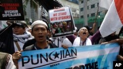 Para demonstran Muslim meneriakkan takbir dan slogan-slogan dalam Aksi "Peduli Muslim Uighur" dalam aksi unjuk rasa di depan Kedutaan China di Jakarta. (AP Photo/ Achmad Ibrahim)