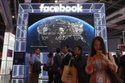Visitors past by the booth for social media giant Facebook at the China International Import Expo in Shanghai, Nov. 6, 2019.