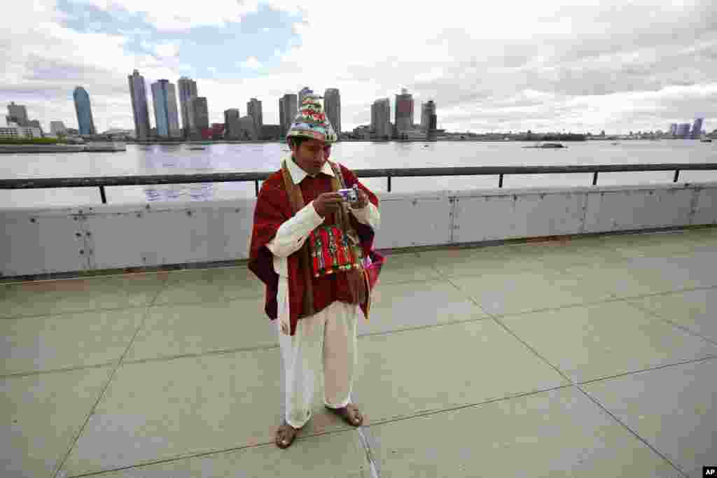 Tomas Mamani dari La Paz, Bolivia, melihat kameranya setelah mengambil foto di luar markas besar PBB di New York (22/9). (AP/Jason DeCrow) &nbsp; 