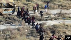 This photo provided by the Rumaf, a Syrian Kurdish activist group, which has been authenticated based on its contents and other AP reporting, shows people fleeing rebel-held eastern neighborhoods of Aleppo, Nov. 27, 2016.