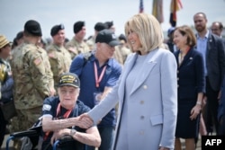 Ibu negara Prancis Brigitte Macron menyambut para veteran PD II saat mereka tiba di Bandara Deauville-Normandie, di Saint-Gatien-des-Bois, Prancis Senin (3/6).