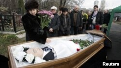 Nataliya Magnitskaya (L), mother of Sergei Magnitsky, grieves over her son 's body during his funeral at a cemetery in Moscow November 20, 2009.