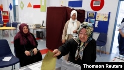 A woman casts her ballot at a polling station during a mayoral election re-run in Istanbul, June 23, 2019. 