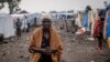 FILE - A woman walks at the Kayembe camp for dislaced persons, near Goma, Democratic Republic of Congo, Aug. 30, 2021.