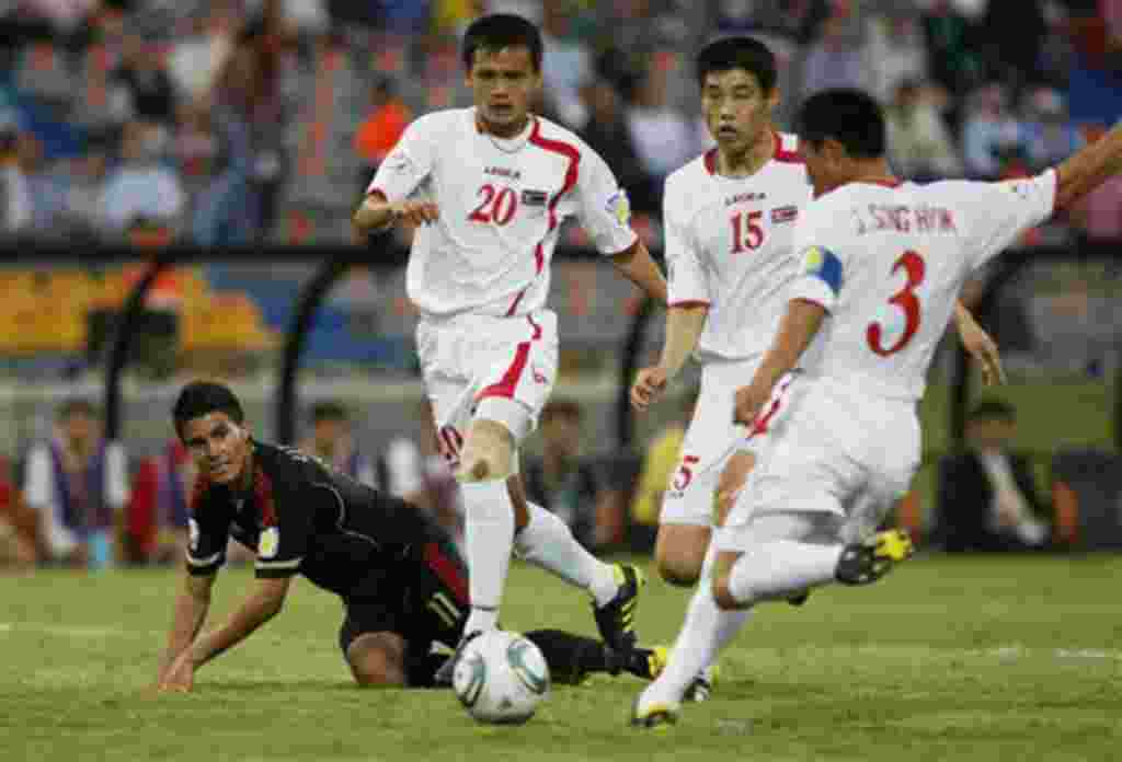 North Korea's Jang Song Hyok, right, kicks the ball that after hitting on teammate Ri Yong Chol, second from right, resulted in an own goal during a U-20 World Cup group F soccer match against Mexico in Medellin, Colombia, Monday, Aug. 1, 2011. (AP Photo/