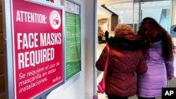 FILE - A sign announcing a face mask requirement is displayed at a hospital in Buffalo Grove, Ill., on January 13, 2023. (AP Photo/Nam Y. Huh)