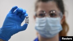 英国伦敦的盖伊医院，一名医务人员拿着一剂辉瑞/BioNTech生产的新冠疫苗（2020年12月8日）。