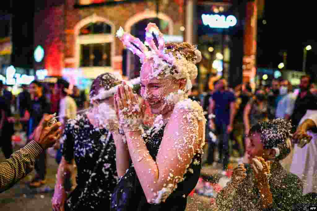 A woman is sprayed with foam as she celebrates the New Year in Kuala Lumpur, Malaysia.