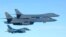 In this photo released by Japan Air Self Defense Force, U.S. Air Force B-1B bombers, top, fly with a Japan Air Self Defense Force F-2 fighter jet over Japan's southern island of Kyushu, just south of the Korean Peninsula, during a Japan-U.S. joint exercis