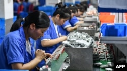 ARCHIVO - Empleados trabajan en una línea de producción de disyuntores en una fábrica de una empresa de electrónica en Fuyang, en la provincia oriental china de Anhui, el 30 de julio de 2024.