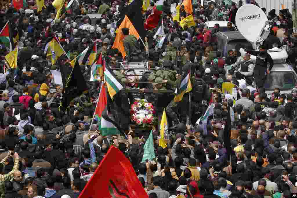 Palestinians take part in the funeral of Maysara Abu Hamdiyeh in the West Bank city of Hebron, April 4, 2013. 