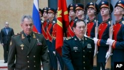 Russian Defense Minister Sergei Shoigu, left, and China's Defense Minister Wei Fenghe review an honor guard prior to their talks in Moscow, Russia, April 3, 2018.