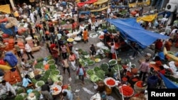 Warga berbelanja di pasar sayur grosir yang ramai setelah pihak berwenang melonggarkan pembatasan menyusul penurunan kasus COVID-19, di kawasan lama Delhi, India, 23 Juni 2021. (REUTERS/Adnan Abidi)
