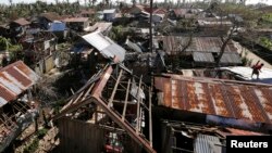 Rumah-rumah hancur akibat topan Hagupit melanda kota Samar, Filipina tengah (8/12). Bencana alam seperti ini adalah sedikit dari banyak tanda perubahan iklim yang terjadi tahun 2014.