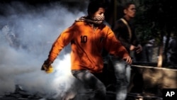 周日开罗解放广场上的埃及抗议者与安全部队发生冲突时四处奔跑