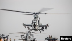 FILE - An AH-1Z Viper from the 11th Marine Expeditionary Unit prepares for takeoff aboard the amphibious assault ship USS Boxer as it transits the Strait of Hormuz, off Oman, in this U.S. Navy photo.