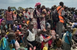 FILE - Men, women and children line up to be registered with the World Food Programme (WFP) for food distribution in Old Fangak, in Jonglei state, South Sudan, June 17, 2017.