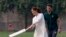 Britain's Kate, Duchess of Cambridge, bats as Pakistani cricketer Shaheen Afridi looks on during her visit to the Pakistan Cricket Academy in Lahore, Pakistan, Oct. 17, 2019.